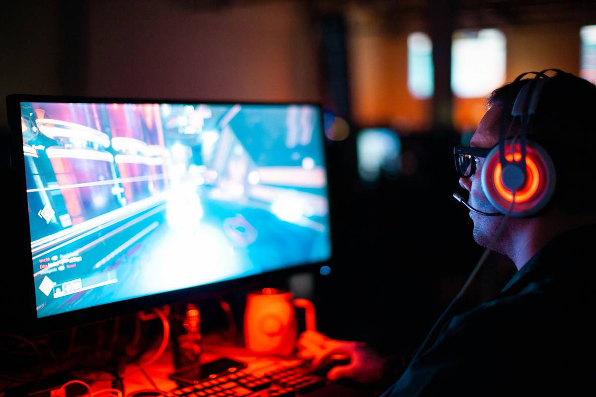 Gamer using properly sized gaming chair pillow with secure straps during intense session